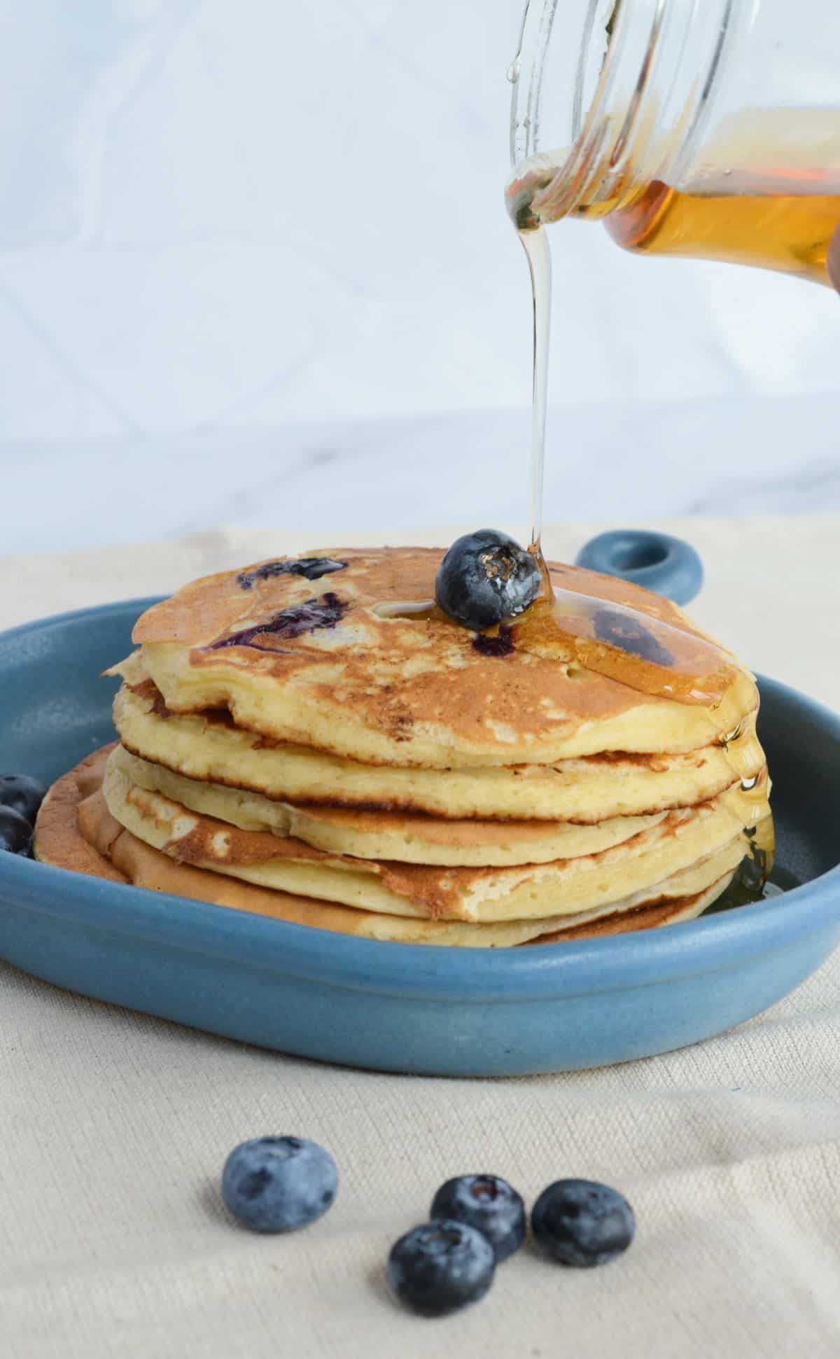 pancakes aux bleuets avec du sirop d'érable versé dessus