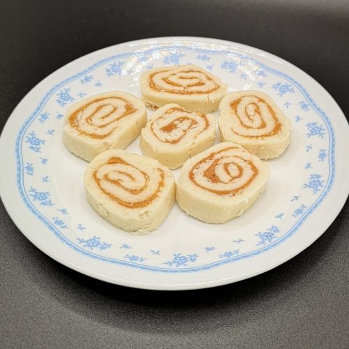 Des bonbons aux patates roulés sur une assiette blanche et bleue.