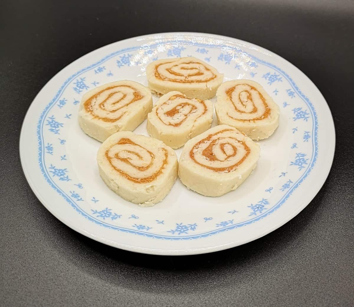 Des bonbons aux patates roulés sur une assiette blanche et bleue.